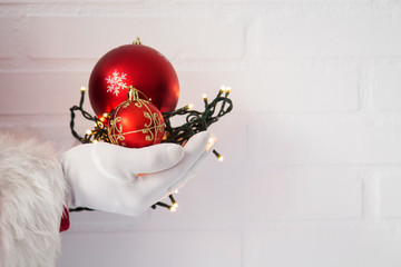 Santa Claus hand holding christmas ball. new year and christmas greeting card