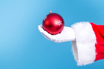 Santa Claus hand holding christmas ball. new year and christmas greeting card