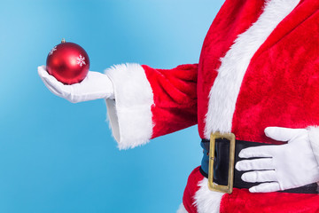 Santa Claus hand holding christmas ball. new year and christmas greeting card