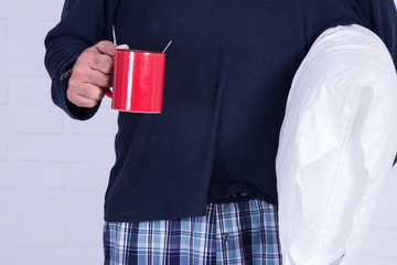 Fototapeta na wymiar man with pillow and cup of coffee isolated