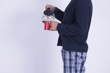 man with coffee cup and coffee maker on brick wall