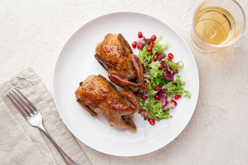 Whole roasted quail on white plate