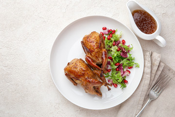 Whole roasted quail on white plate