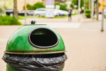 Green pastic garbage bin or can on street