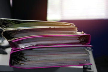 Stacks paper files unfinished document achieves on folders papers at busy work desk office. Soft focus