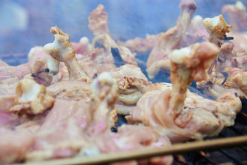 Close up raw chicken on the grill with smoke.