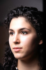 Fototapeta premium Beautiful young woman with dark curly hair portrait
