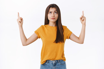 Skeptical, unsure good-looking brunette woman smirk with dismay or scorn, frowning suspicious,...
