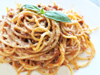 Spaghetti Bolognese with minced beef, onion, chopped tomato, garlic, olive oil, stock cube, tomato puree and Italian herb. Traditional Italian food in a white plate.