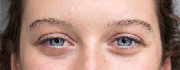 Woman face with blue color eyes close up