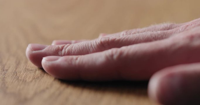 Slow motion man hand touch oil finished oak wood surface