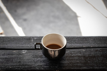 Coffee cup on a black wood table, outside