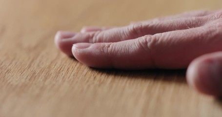 Slow motion man hand touch oil finished oak wood surface