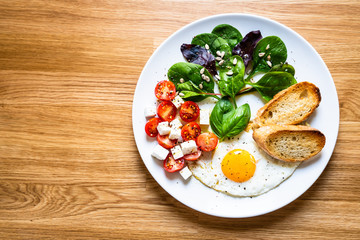 Breakfast - fried egg, toasts and vegetable salad