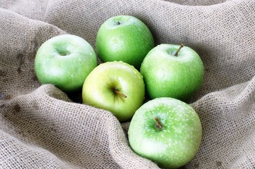 Mele verdi sul sacco di juta