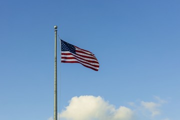 Beautiful view of American flag blue sky with white clouds background.