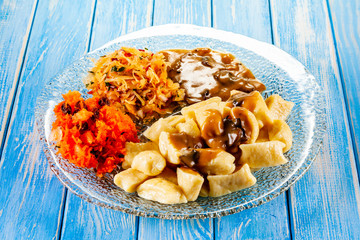 Potato noodles - dumplings on wooden background