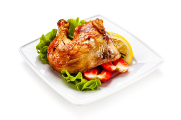 Grilled chicken leg with vegetables on white background