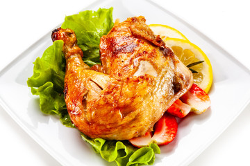 Grilled chicken leg with vegetables on white background
