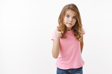 Fototapeta premium Strict serious-looking young blond little girl child, shaking one finger angry stare camera scolding younger brother for making mess, purse lips displeased, standing white background