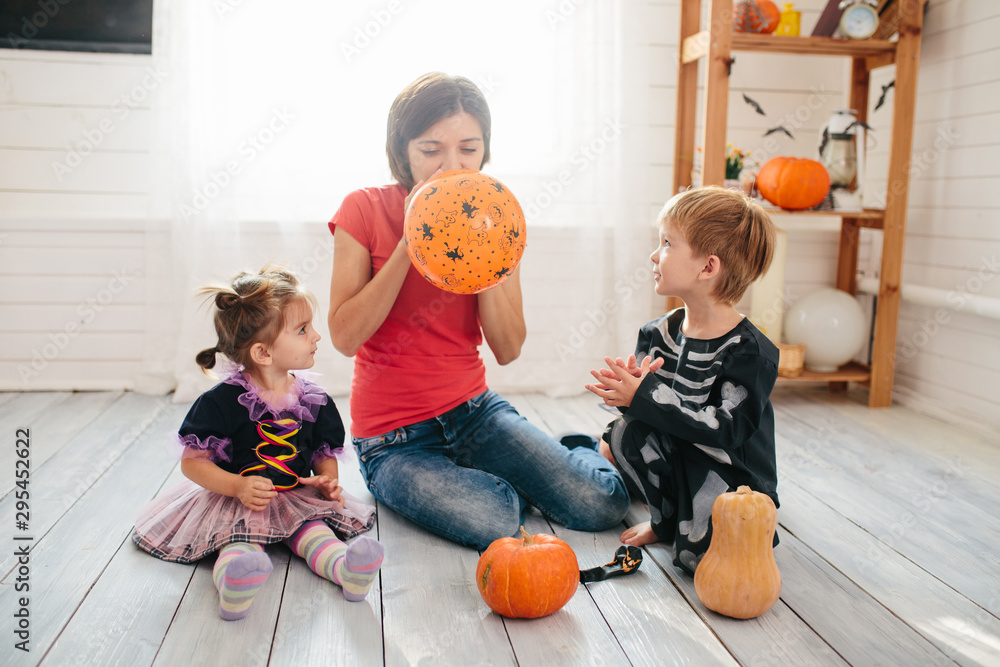 Wall mural happy family of mother and children prepare for halloween in decorate the home