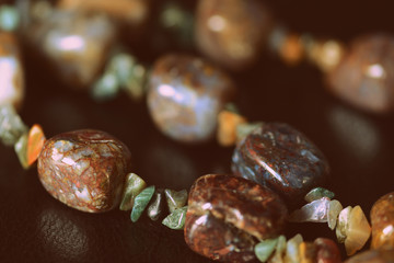 Necklace made of natural stone on a dark background close-up, retro style