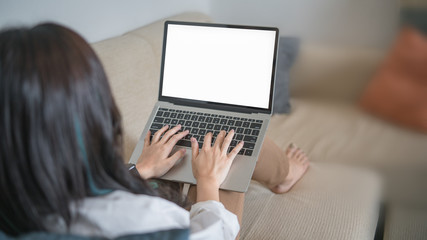 Casual young woman using laptop in living room at home