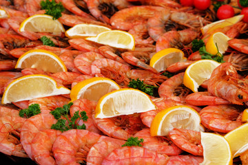 Shrimps is serving on a plate on open food festival event, close up. Sea food in food court.