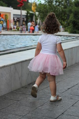 beautiful girl walks with her parents at sea. the family is happy.