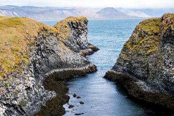 The Cliffs of Arnastapi auf Island mit einer auffallend erodierten schwarzen Steilküste mit Höhlen, Felstoren und Resten von Kratern © Ernst August