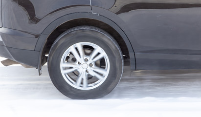 Fototapeta na wymiar A car wheel glides on a snowy road