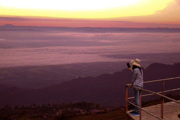 Fototapeta na wymiar Asian female tourists are a selfie at dawn, Sunrise View, The mist.
