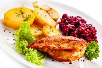 Grilled chicken breast, baked potatoes and vegetables on white background