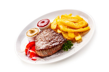 Grilled steaks, French fries and vegetables