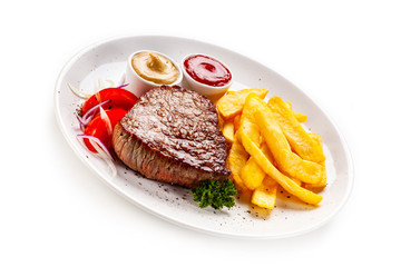 Grilled steaks, French fries and vegetables