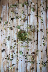 Glass with herbal tea on wooden background with dry herbs
