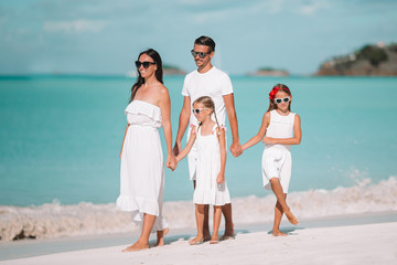 Happy beautiful family of four on white beach