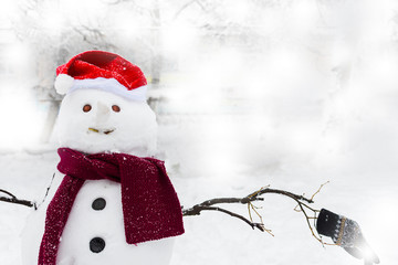 snowman in Santa hat and scarf outdoors
