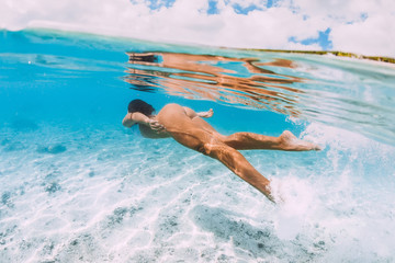 Young attractive woman swimming underwater in transparent blue ocean at Mauritius