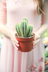 the girl holds a cactus. 