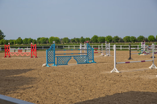 Wooden barriers for jumping horses as a background. Colorful photo of equestrian obstacles. Empty field for horse jumping event competition . Image of show jumping poles on the training field.