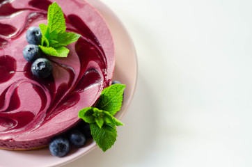 Baked vanilla and berries flavour cheesecake swirled with blueberry sauce on a digestive biscuit crumb