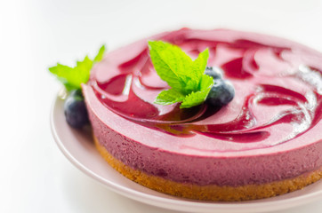 Baked vanilla and berries flavour cheesecake swirled with blueberry sauce on a digestive biscuit crumb