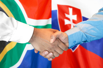Business handshake on the background of two flags. Men handshake on the background of the South Africa and Slovakia flag. Support concept