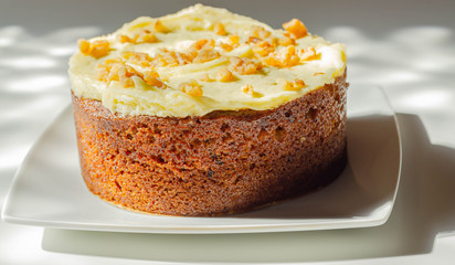 Carrot cake filled and topped with cream cheese buttercream and decorated with walnuts