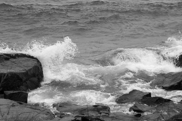 Lake Waves crashing on a rocky shore in black and white.