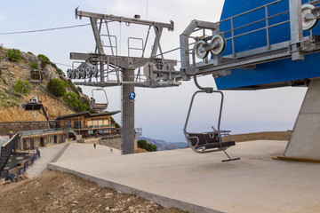 An empty ski lift on a sunny summer day. Mountain slopes.