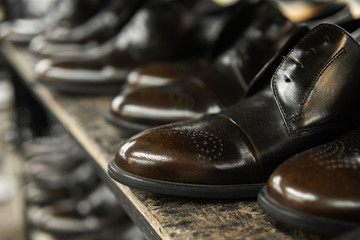 A lot of new black shiny shoes on a shelf. Shoe factory, finished goods warehouse.