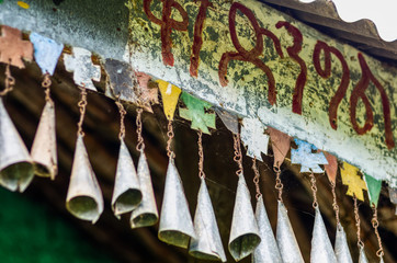 Small ornamental bells hanging on colored crosses in a house lintel in Ethiopia. Culture, religion and travel concept