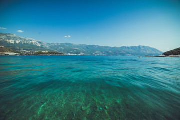 Fototapeta na wymiar Adriatic coast in summer. The height of the tourist season. Transparent warm sea and mountains. Montenegro.